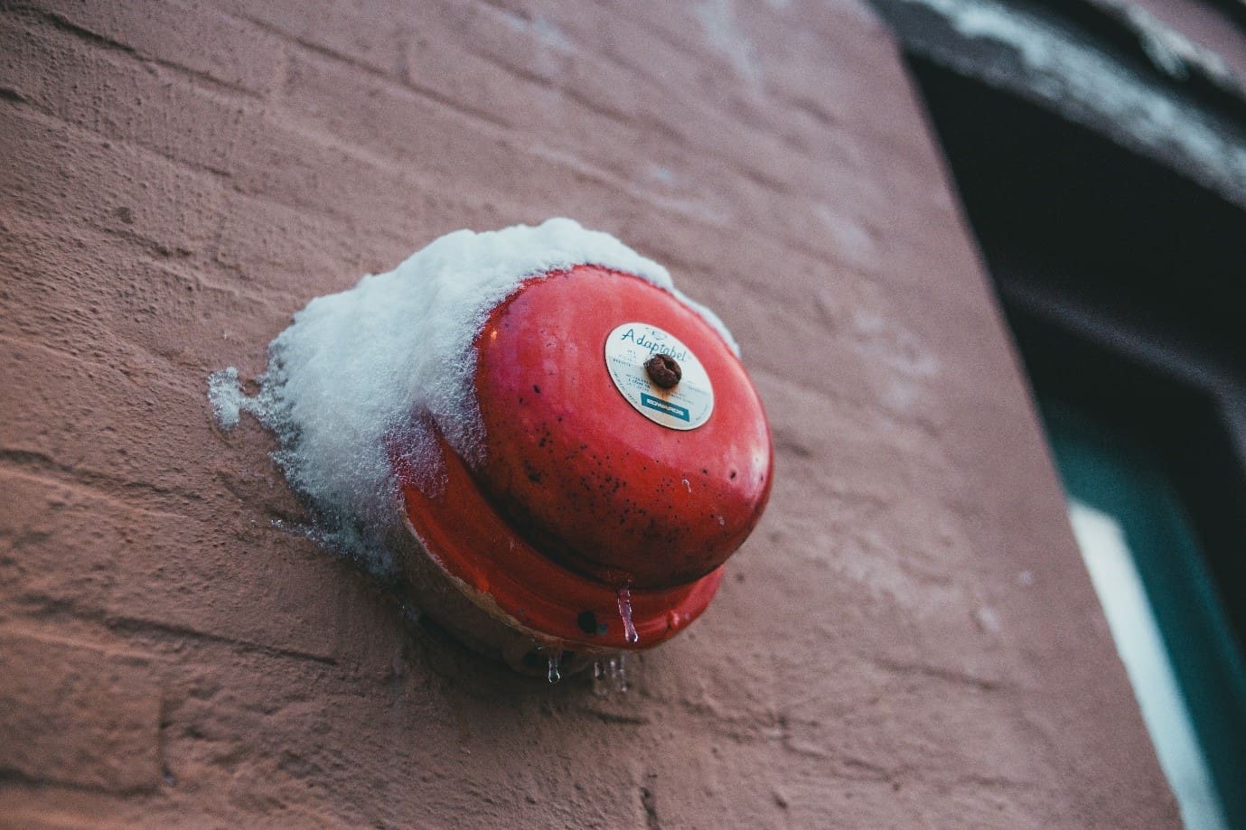 Red alarm bell cover in ice