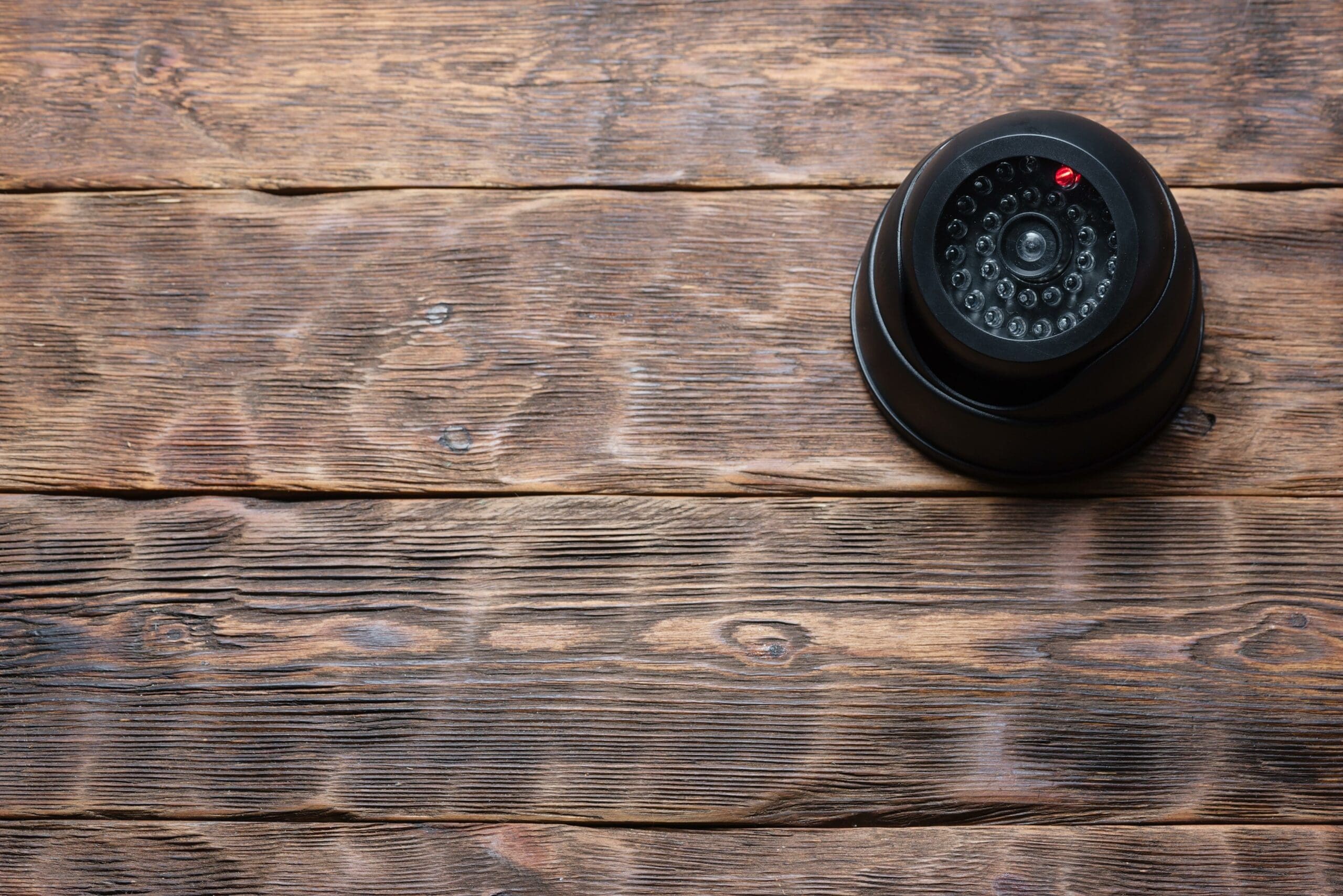 Security camera on wooden wall.